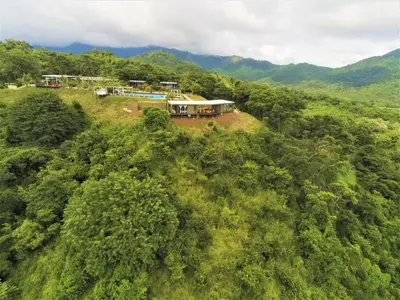 an aerial view of a house on a hill in the jungle at La Colina Pura Vista in Bejuco