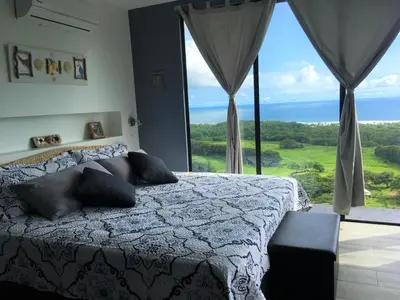 a bedroom with a bed and a large window at La Colina Pura Vista in Bejuco