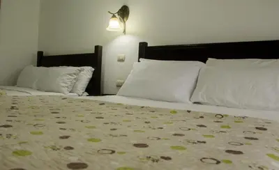 a bedroom with two beds with white pillows at Hotel Cielo Azul Resort in Tilarán