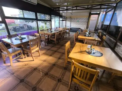 a restaurant with wooden tables and chairs and windows at Hotel Cielo Azul Resort in Tilarán