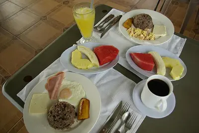 a table with plates of food and a cup of coffee at Hotel Cielo Azul Resort in Tilarán