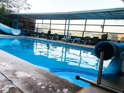 a swimming pool with a slide in the middle at Hotel Cielo Azul Resort in Tilarán