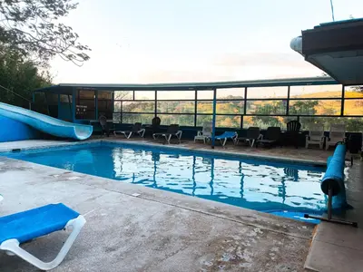 a swimming pool with a slide in the middle at Hotel Cielo Azul Resort in Tilarán