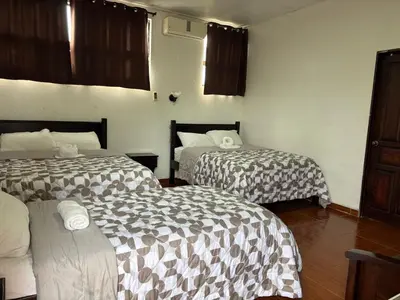 two beds in a hotel room withskirts at Hotel Cielo Azul Resort in Tilarán