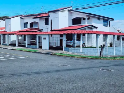 a white building with red roofs on a street at Don Carlos Place LOWER UNIT in Alajuela City