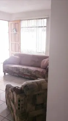 a living room with a bed and a couch at Don Carlos Place LOWER UNIT in Alajuela City