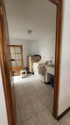 a room with a bedroom with a bed and a doorway at Don Carlos Place LOWER UNIT in Alajuela City