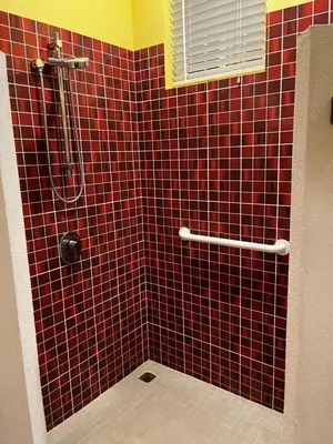 a red tiled bathroom with a shower and a toilet at Pacific View Condominium in Playa Azul in Playa Azul