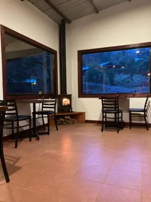 a room with two large windows and a table and chairs at Curuba Lodge in El Copey