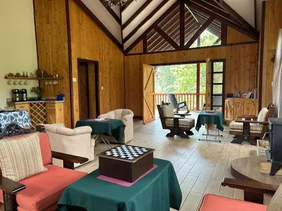 a living room with tables and chairs in a building at Curuba Lodge in El Copey