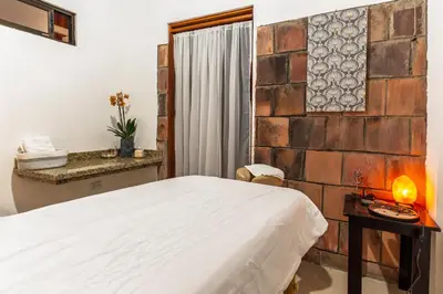 a bedroom with a bed and a brick wall at Hotel Ribera La Paz in San Ramón