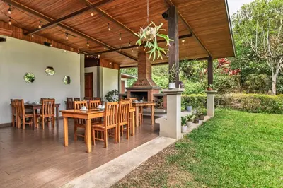 a patio with a table and chairs and a fireplace at Hotel Ribera La Paz in San Ramón