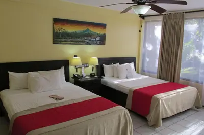 a hotel room with two beds and a window at Best Western El Sitio Hotel in Liberia
