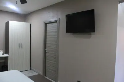 a bedroom with a flat screen tv on the wall at Best Western El Sitio Hotel in Liberia