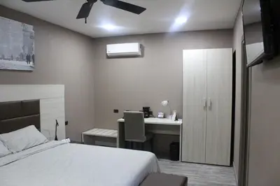 a bedroom with a bed and a desk with a ceiling fan at Best Western El Sitio Hotel in Liberia