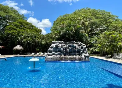 a fountain in the middle of a swimming pool at Best Western El Sitio Hotel in Liberia