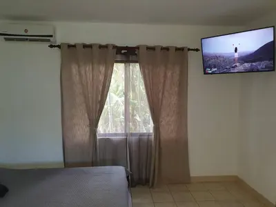 a bedroom with a window with a tv on the wall at Apart Hotel Marina Loft 214 in Coco