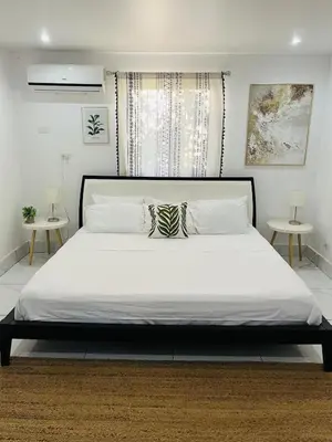 a bedroom with a large white bed with two tables at Casa Ophelia in Tamarindo