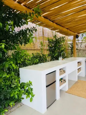 an outdoor kitchen with a white counter in a garden at Casa Ophelia in Tamarindo