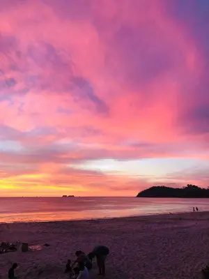 a group of people standing on a beach at sunset at Casa Ophelia in Tamarindo