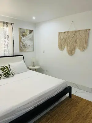 a white bedroom with a bed and a window at Casa Ophelia in Tamarindo