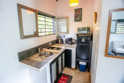 a small kitchen with a sink and a refrigerator at Macaw Villa - Riverfront With A Pool in Uvita