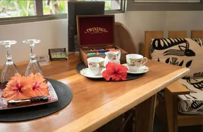 a table with two cups and a plate with flowers on it at Macaw Villa - Riverfront With A Pool in Uvita