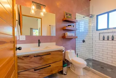 a bathroom with a sink and a toilet and a mirror at La Joya de Nosara in Playa Pelada