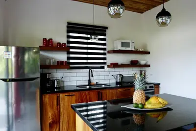 a kitchen with a table with a plate of pineapple on it at La Joya de Nosara in Playa Pelada
