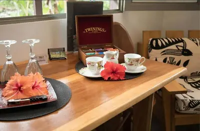 a table with two cups and a plate with flowers on it at La Rana Deluxe Villa - Riverfront With A Pool in Uvita