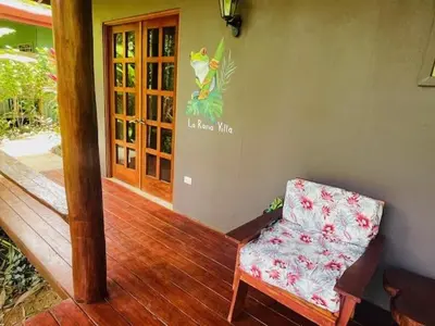 a living room with a chair and a door at La Rana Deluxe Villa - Riverfront With A Pool in Uvita