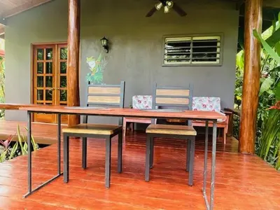 a wooden table with two chairs and a dining room at La Rana Deluxe Villa - Riverfront With A Pool in Uvita