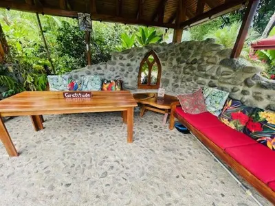 a living room with a wooden table and a couch at La Rana Deluxe Villa - Riverfront With A Pool in Uvita