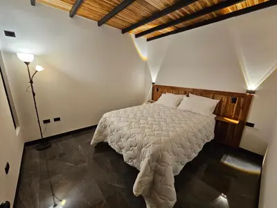 a bedroom with a large bed with a wooden headboard at Wind Houses, Casas de Viento in Monteverde Costa Rica