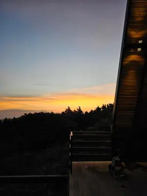 a person sitting on a bench looking at the sunset at Wind Houses, Casas de Viento in Monteverde Costa Rica