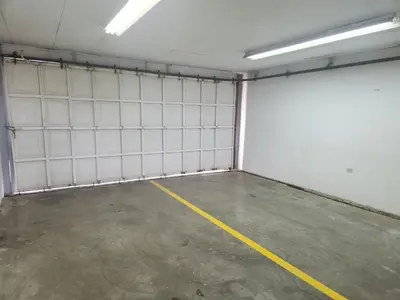 an empty garage with white walls and a yellow line at Hostel El Pretal in Liberia