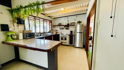 a large kitchen with a counter and a refrigerator at Hostel El Pretal in Liberia