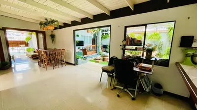 a living room with chairs and a table and a dining room at Hostel El Pretal in Liberia