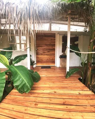 a wooden walkway leading to a room with a thatch roof at Buendía Lux Piña Suite Hidden Gem Near Beach with Pool in Potrero
