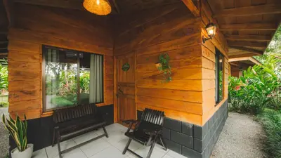 a porch of a wooden house with a bench at Eden Organic Farm & Bungalows in Fortuna