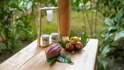 a wooden table with a bowl of fruit on it at Eden Organic Farm & Bungalows in Fortuna