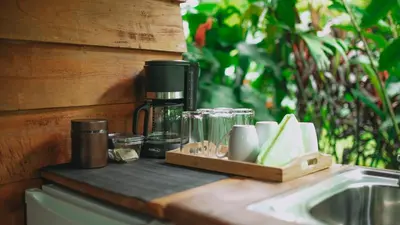 a coffee maker on a counter next to a sink at Eden Organic Farm & Bungalows in Fortuna