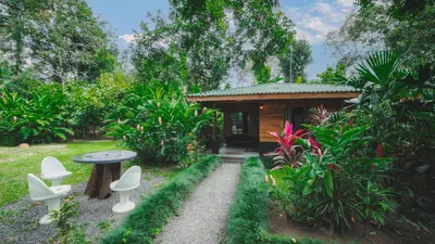 a small building with a table and chairs in a garden at Eden Organic Farm & Bungalows in Fortuna