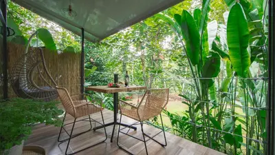 a room with a table and chairs on a patio at Eden Organic Farm & Bungalows in Fortuna