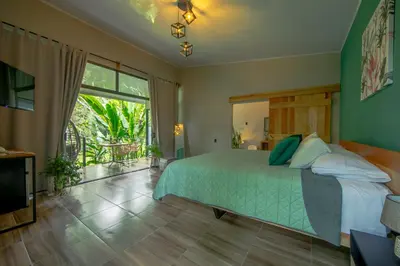 a bedroom with a bed and a large window at Eden Organic Farm & Bungalows in Fortuna