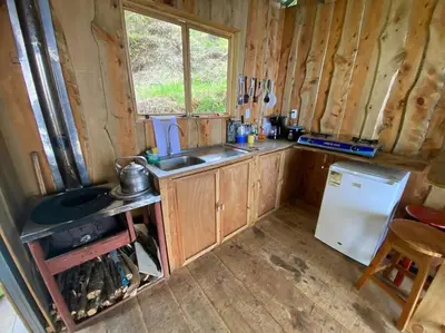 a small kitchen with a sink and a refrigerator at Cabaña la Chispita, Alto Jaular in Rivas