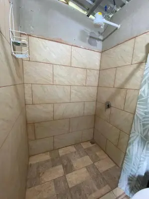a bathroom with a shower with a tiled floor at Cabaña la Chispita, Alto Jaular in Rivas