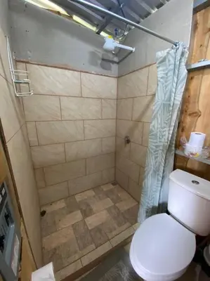 a bathroom with a toilet and a shower at Cabaña la Chispita, Alto Jaular in Rivas