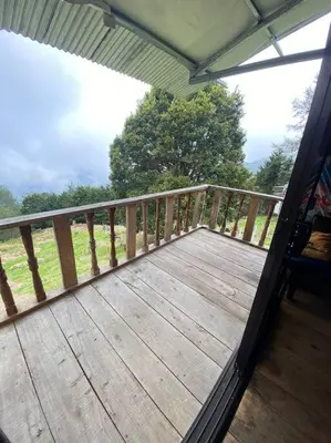 a porch with a wooden deck with a fence at Cabaña la Chispita, Alto Jaular in Rivas