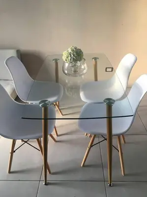 two white chairs and a glass table with a vase of flowers at Casa céntrica en San Ramón in San Ramón
